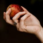 a hand wearing a snake ring