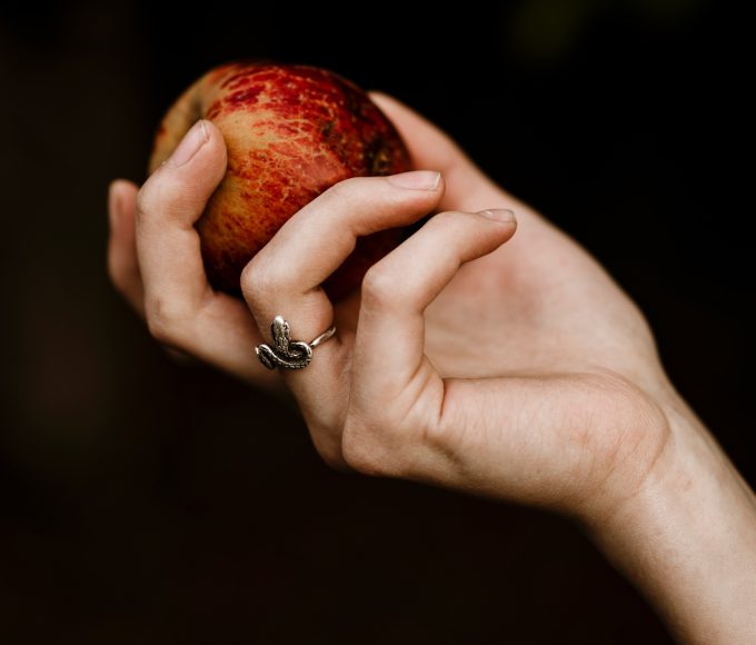 a hand wearing a snake ring