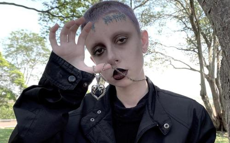 a short hair person wear a skull heart pendant