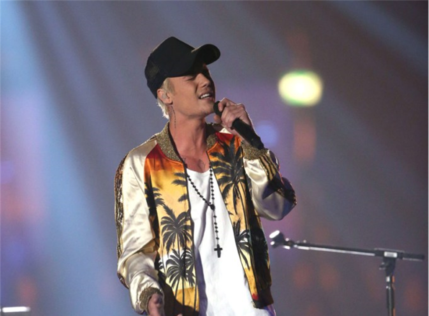 Justin Biber wear a cross pendant on his  concert