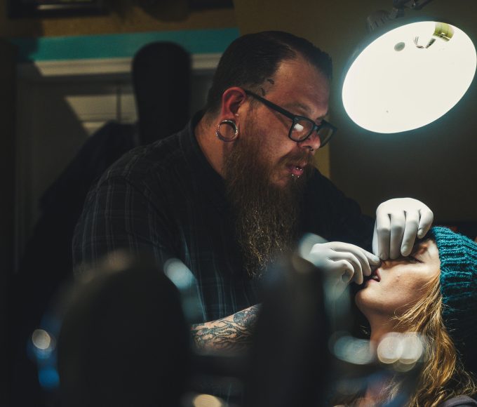 a man doing nose piercing